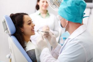 smiling patient at dentist getting teeth cleaned